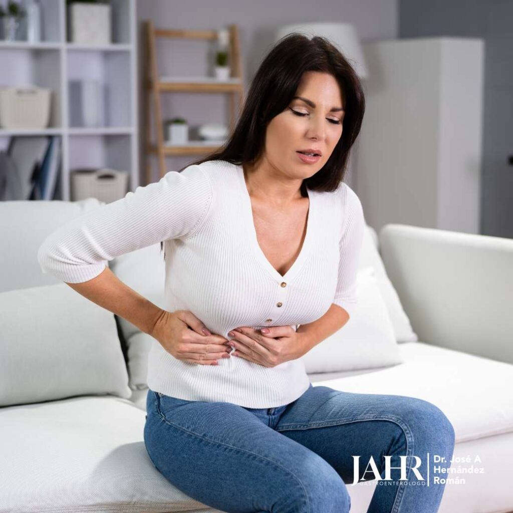 Mujer con dolor abdominal en el sofá